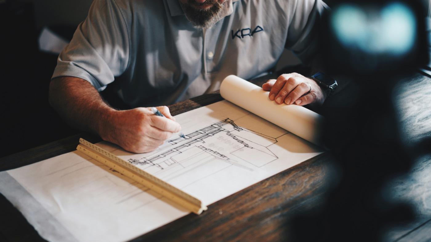 Architect reviewing building blueprints and plans at a drafting table